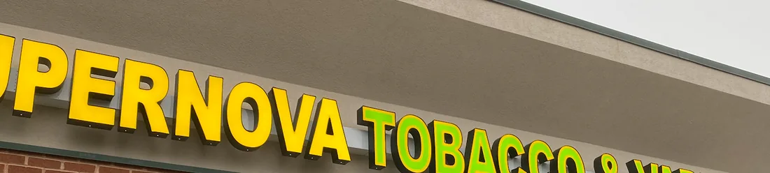 The glowing Supernova Tobacco & Vape channel-letter sign lit up at the storefront.